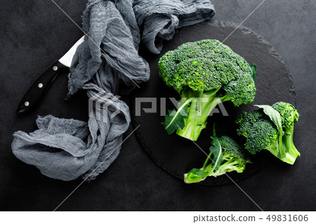 Fresh broccoli florets on black background, top 49831606