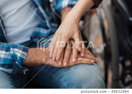 A man and a woman are sitting holding hands. A man and a woman are sitting holding hands. 49832964