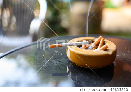 Cigarette burning with smoking on ashtray 49835860