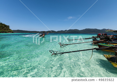 Wooden long-tail boats anchored on turquoise water 49835922