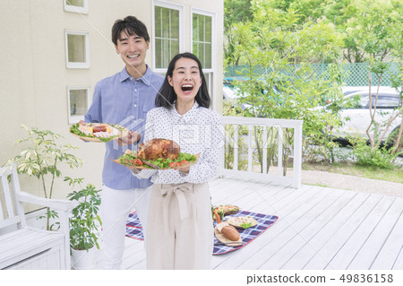 A couple standing with food on the deck A couple standing with food on the deck 49836158