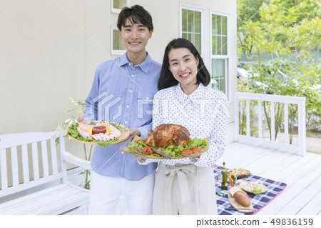 A couple standing with food on the deck A couple standing with food on the deck 49836159