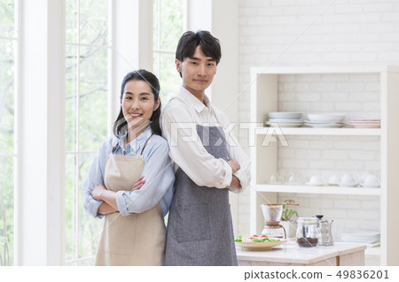 Couple standing back to back at the windowsill 49836201