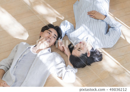 Couple sleeping on the floor and holding hands Couple sleeping on the floor and holding hands 49836212
