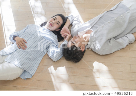 Couple sleeping on the floor and holding hands 49836213