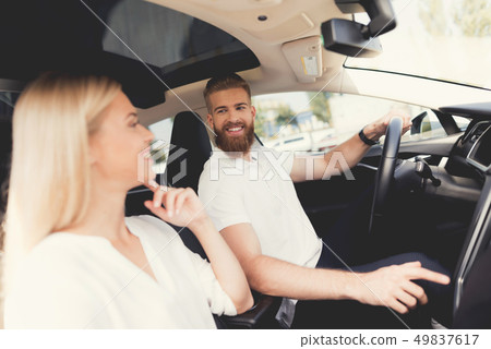 A young couple is sitting in the cabin of a car. 49837617