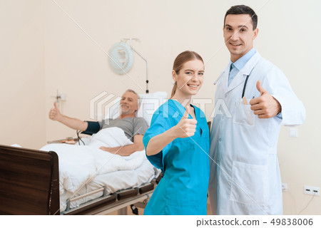 man lies on a cot. Doctor and a nurse help him. 49838006