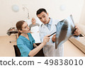 man lies on a cot. Doctor and a nurse help him. 49838010