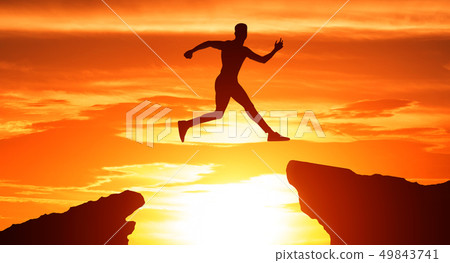 Silhouette of man jump through the gap between hills Silhouette of man jump through the gap between hills 49843741
