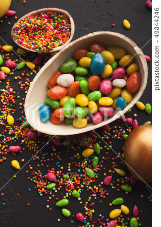 Chocolate egg and colorful candies Chocolate egg and colorful candies 49844246