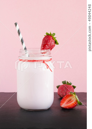 Strawberry milkshake with berry in mason jar on pink. Close up. Summer drink. Strawberry milkshake with berry in mason jar on pink. Close up. Summer drink. 49844248
