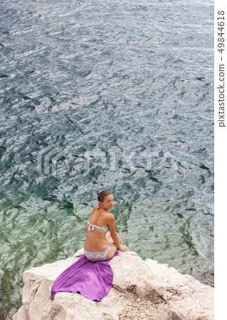 Attractive girl relaxing on a beautiful rocky sea beach. Attractive girl relaxing on a beautiful rocky sea beach. 49844618
