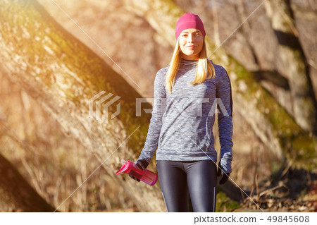Young runner girl with bottle of water in the park 49845608