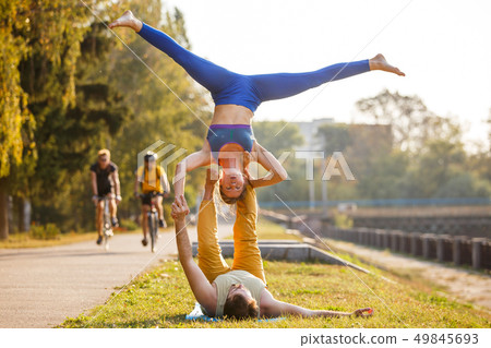 Couple of young man and woman practicing acro yoga 49845693
