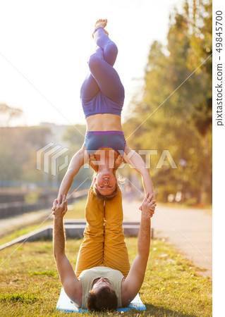 Couple of young man and woman practicing acro yoga 49845700