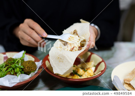 Woman having Arabic food in a restaurant Woman having Arabic food in a restaurant 49849584