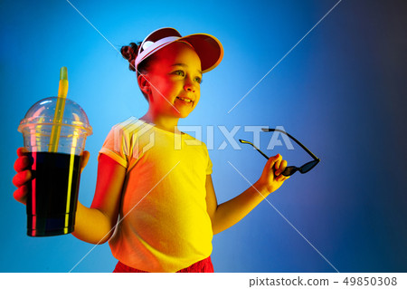 The happy teen girl standing and smiling against blue background. The happy teen girl standing and smiling against blue background. 49850308