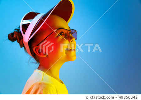 The happy teen girl standing and smiling against blue background. 49850342