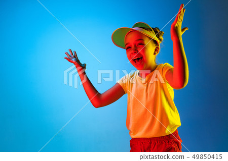 The happy teen girl standing and smiling against blue background. 49850415