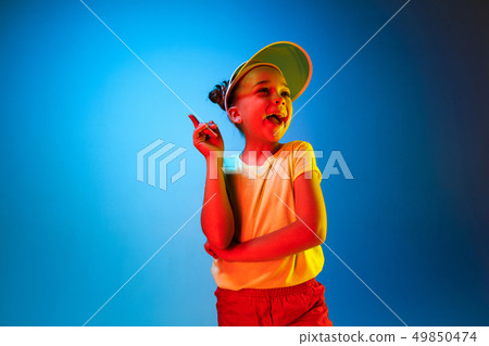 The happy teen girl standing and smiling against blue background. 49850474