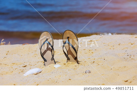 Trendy slippers on white sandy ocean beach. 49851711