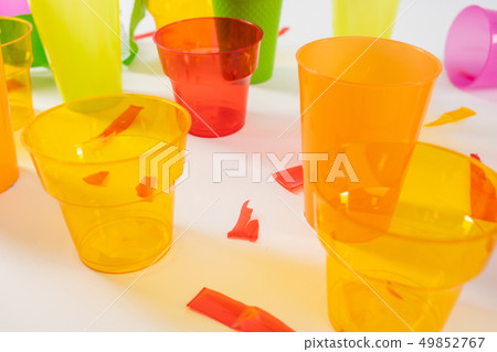Orange transparent cups made of dangerous plastic material 49852767