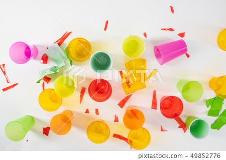 Sharp broken pieces of plastic cups lying on white surface 49852776