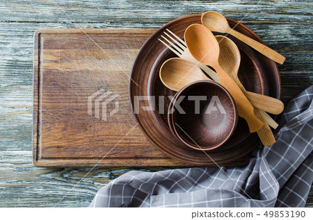 Simple rustic kitchenware on wooden background. Simple rustic kitchenware on wooden background. 49853190