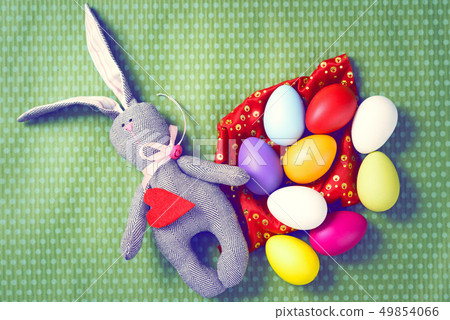 Painted Easter eggs on a green background with white polka dots Painted Easter eggs on a green background with white polka dots 49854066