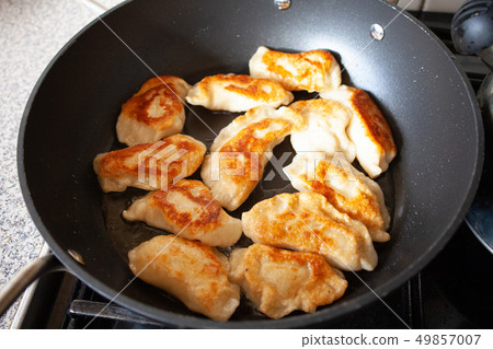 Polish dish pirogi in frying pan. Preparing 49857007