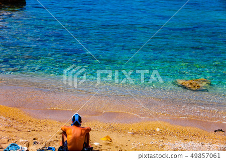 Young hiker in black pants and shirt is sitting on Young hiker in black pants and shirt is sitting on 49857061