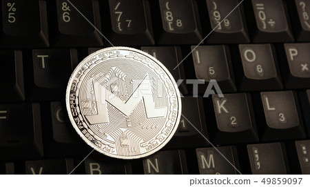Silver Monero XMR coin on laptop keyboard Silver Monero XMR coin on laptop keyboard 49859097