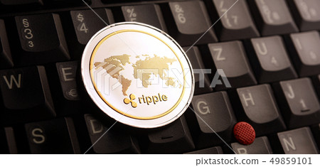 Golden ripple XRP coin over laptop keyboard 49859101