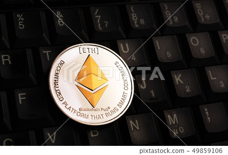 Golden Ethereum ETH coin over black keyboard 49859106