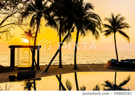Beautiful Silhouette coconut palm tree on sky around swimming pool in hotel resort neary sea ocean beach at sunset or sunrise time Beautiful Silhouette coconut palm tree on sky around swimming pool in hotel resort neary sea ocean beach at sunset or sunrise time 49860582