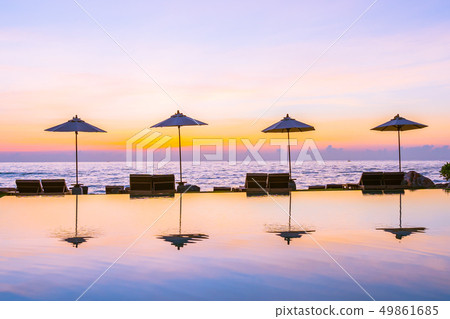 Umbrella and chair around swimming pool in resort hotel for leisure travel and vacation 49861685