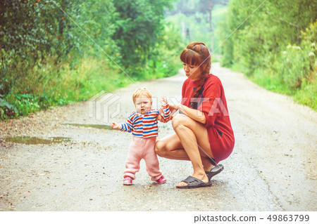 The child learns to walk on the grass The child learns to walk on the grass 49863799