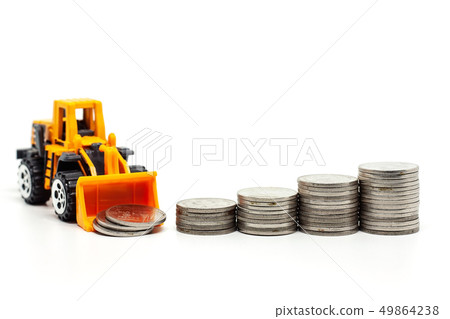 A yellow toy bulldozer with pile of coins 49864238