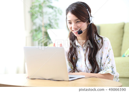 A young lady who plays a personal computer in the living room 49866390