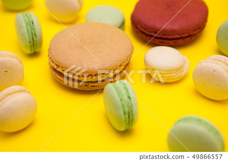 French delicious macaroons dessert over yellow background French delicious macaroons dessert over yellow background 49866557