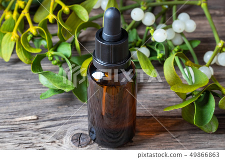 A bottle of mistletoe tincture with fresh plant A bottle of mistletoe tincture with fresh plant 49866863