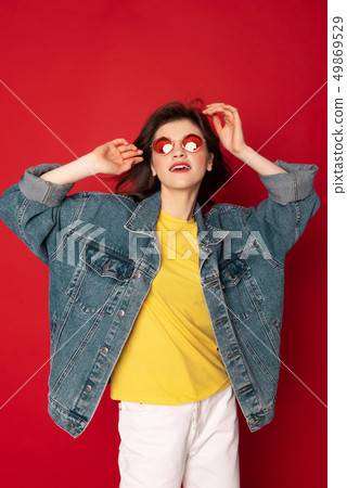 Beautiful hipster girl posing isolated on red 49869529