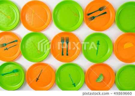 Disposable plastic utensils lying on bright plates 49869660