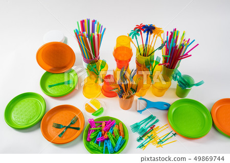 Colorful plates and bright pins lying with forks and straws around 49869744