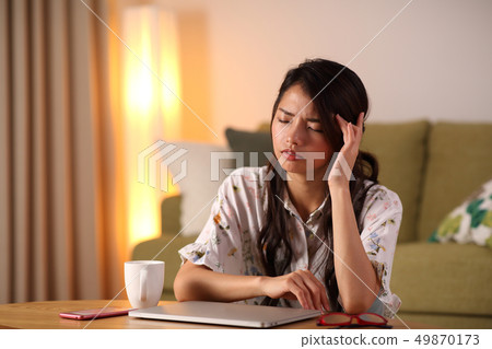 A young lady who plays a personal computer in the living room A young lady who plays a personal computer in the living room 49870173