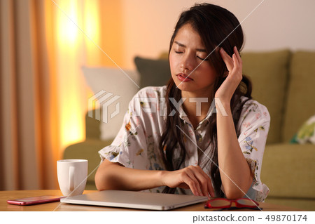 A young lady who plays a personal computer in the living room 49870174