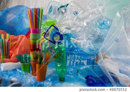 Colorful plastic forks placed in plastic cup and standing near bunch of garbage Colorful plastic forks placed in plastic cup and standing near bunch of garbage 49870552
