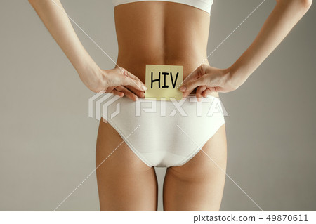 Beautiful young body. Naked back of a woman, isolated on gray background. 49870611