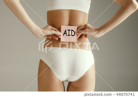 Beautiful young body. Naked back of a woman, isolated on gray background. Beautiful young body. Naked back of a woman, isolated on gray background. 49870741