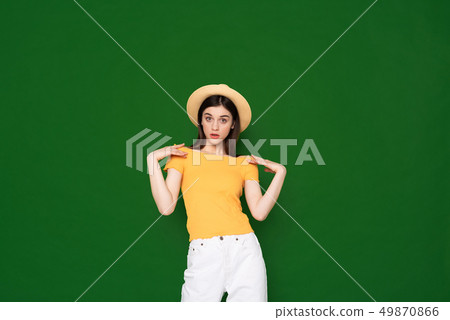 Astonished young pretty girl isolated on green Astonished young pretty girl isolated on green 49870866